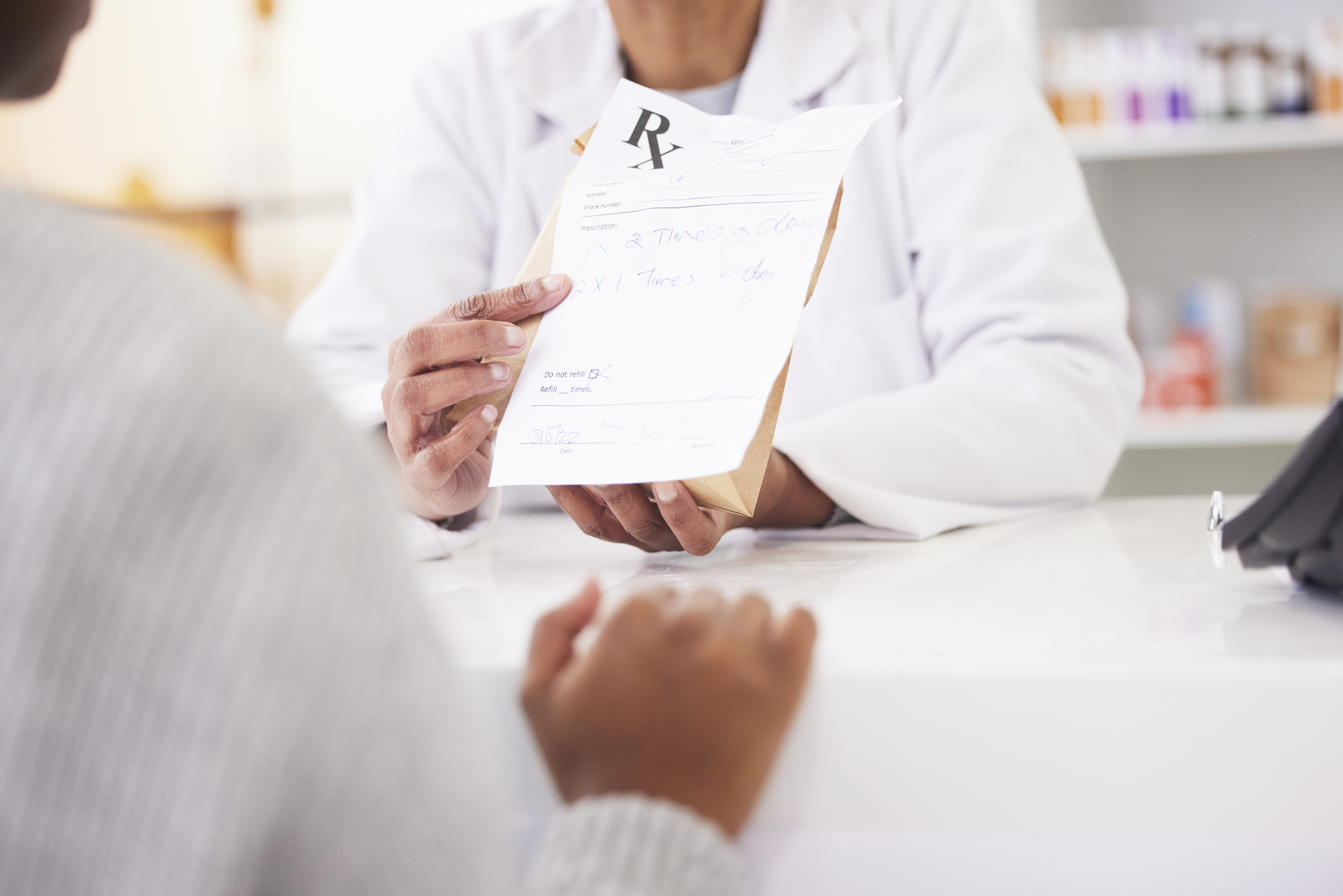 Doctor, hands and patient at pharmacy for medication prescription, drugs or consultation at store. Medical or healthcare professional consulting client on dosage for pharmaceutical product at clinic
